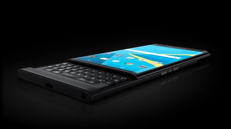A BlackBerry Priv phone lying flat with the keyboard exposed on a black background.