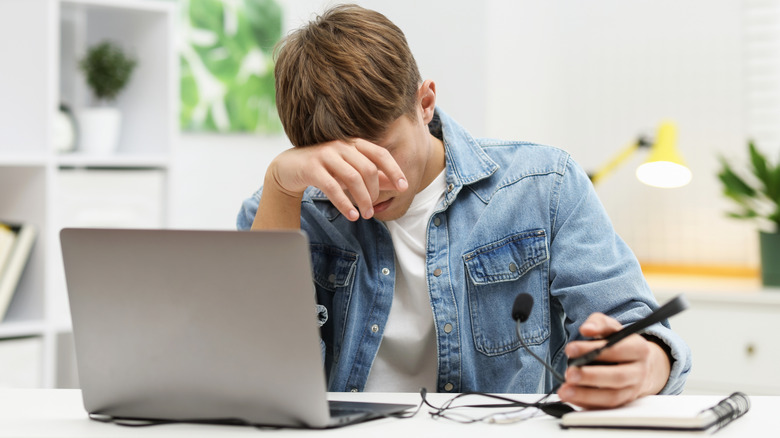 Young person frustrated in an office setting.