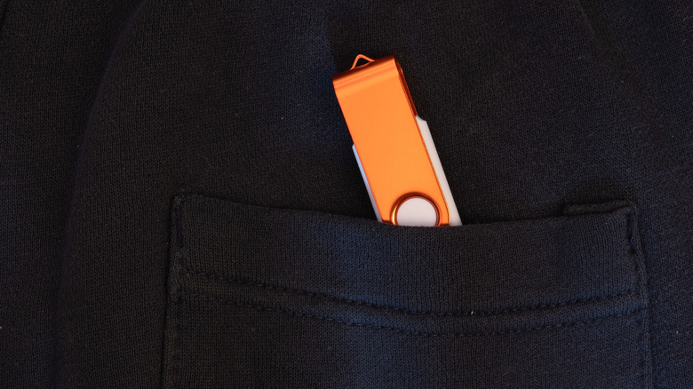 A USB Drive peeking out of a pocket on dark clothing
