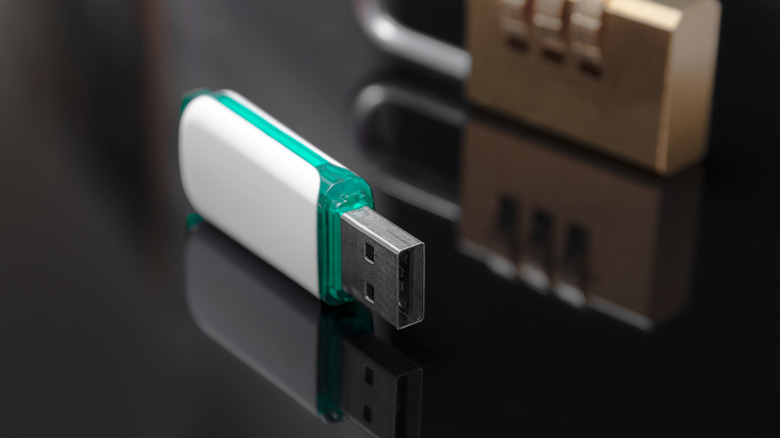 A small white USB drive standing on its side next to a lock