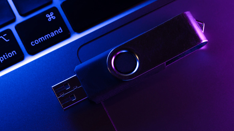 A USB drive on top of a laptop keyboard