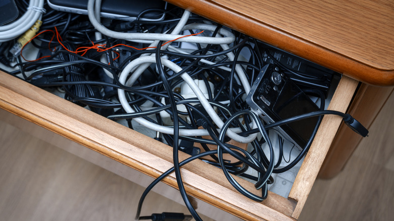 A drawer full of jumbled cables.
