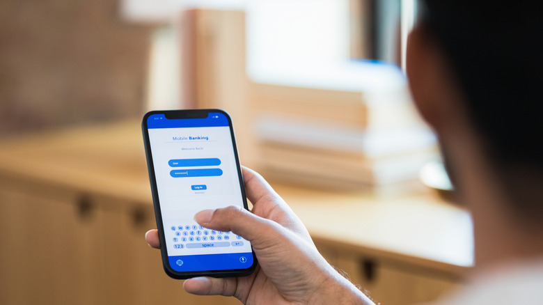 A person entering a password on their phone