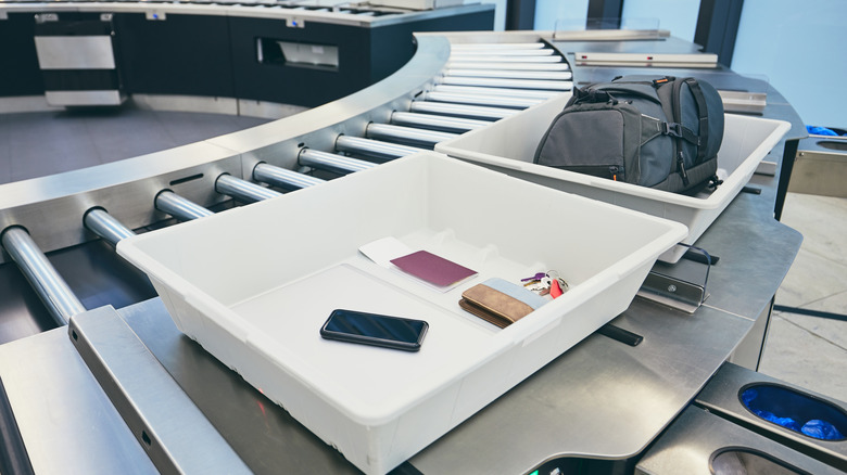 Phone with other valuable items in airport security bin