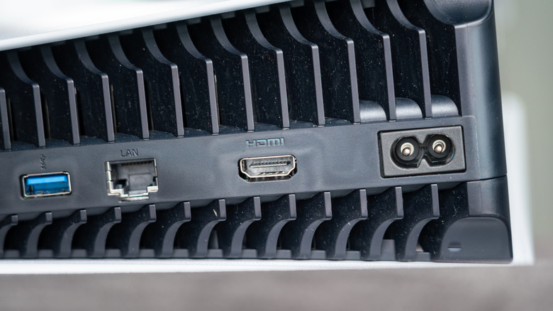 a close up a PlayStation 5 console showing the LAN port, HDMI, power, and USB ports