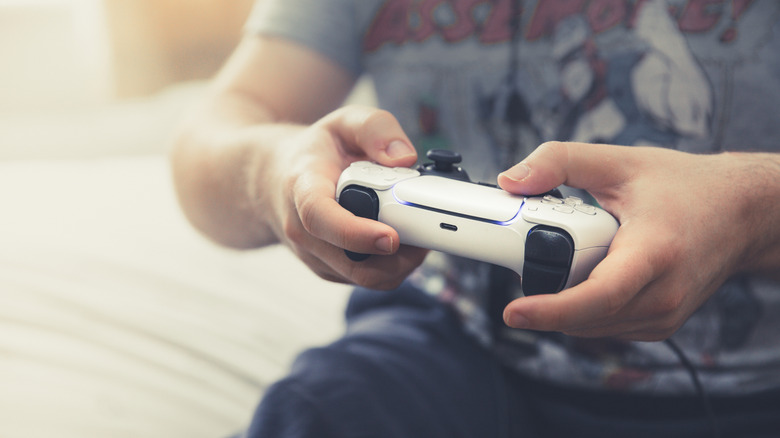 a person holding and using a DualSense Playstation 5 controller