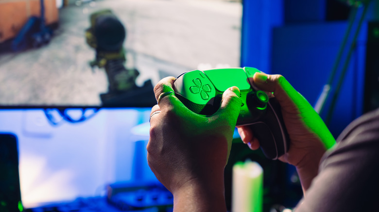 a person playing a game while holding the PlayStation 5 controller