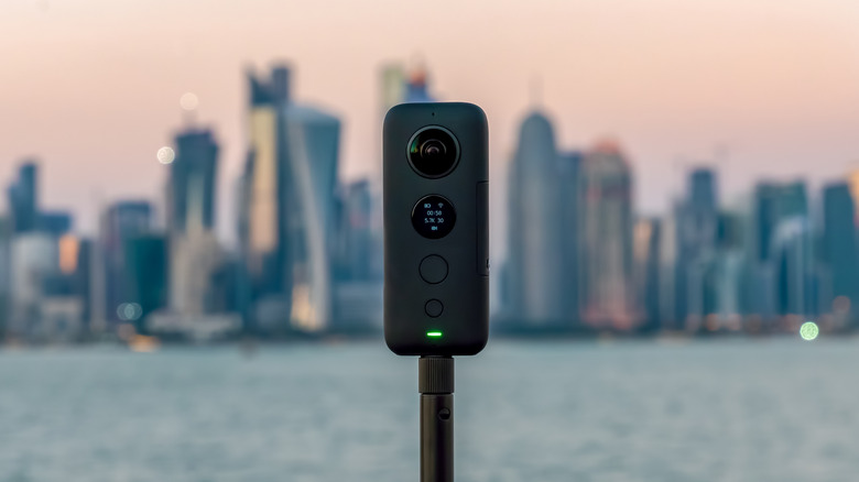 Insta360 One X 360 camera on a tripod with cityscape in the background