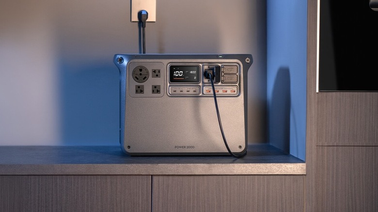 DJI Power 2000 charging via a wall outlet on a kitchen slab