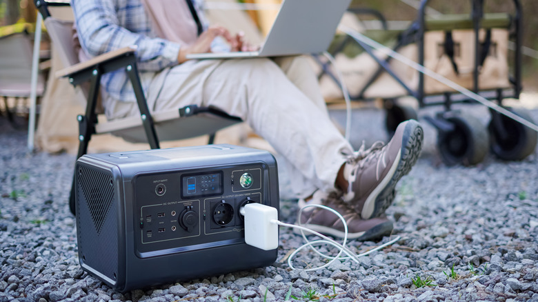 A portable power station being used to charge a laptop in a park