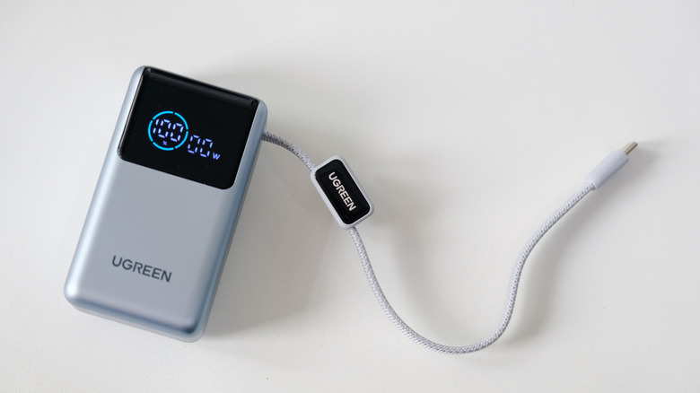 A Ugreen Power Bank with a built-in cable on a white surface