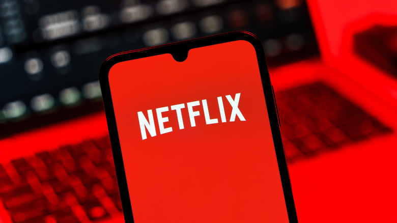 A smartphone showing the Netflix logo on the display