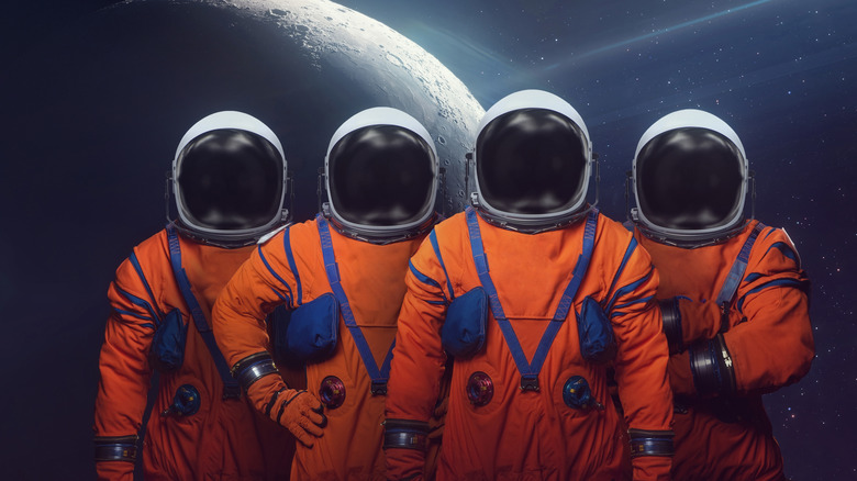 four space suits on a black, space-like background showing the silhouette of the moon