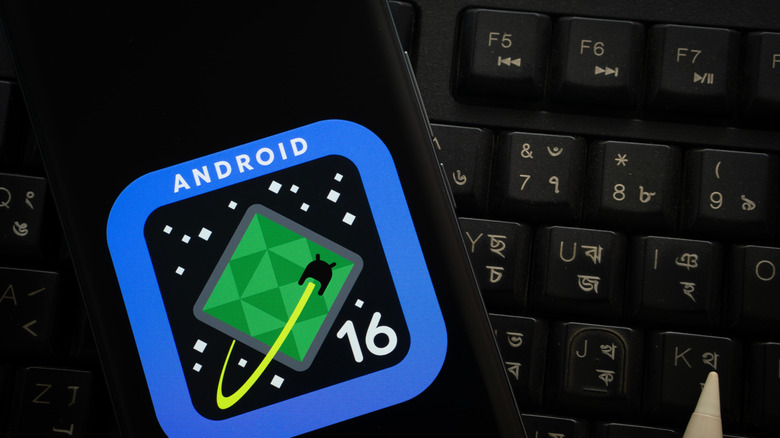 smartphone showing Android 16 logo sitting on top of a keyboard