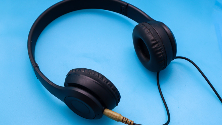 Black headphones with an AUX cable plugged into them