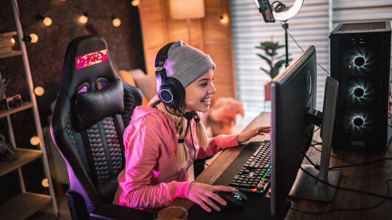 Girl smiling while using a desktop PC with RGB fans visible.
