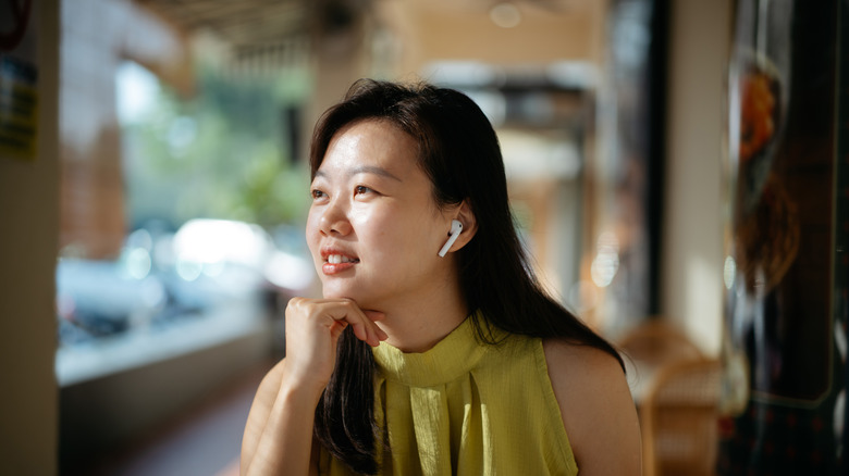 woman in cafe using airpods, concept for ANC