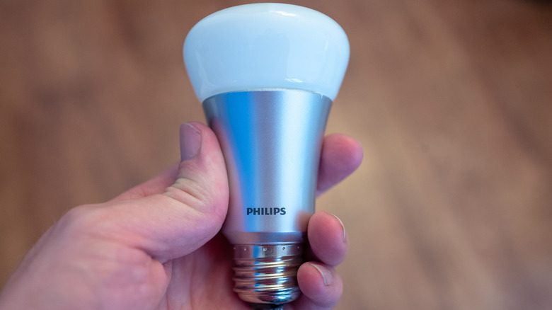Close up of hand holding Philips Hue smart lightbulb