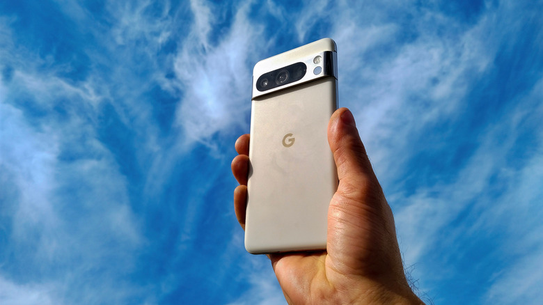 Close-up of a person holding a Pixel 8 Pro with sky in the background