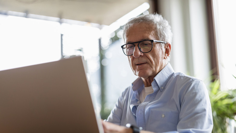 An older man using a laptop.