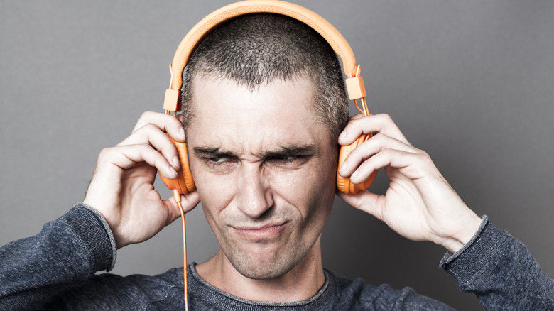 Person looking annoyed while listening to headphones