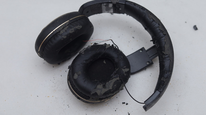 Set of broken headphones on white background