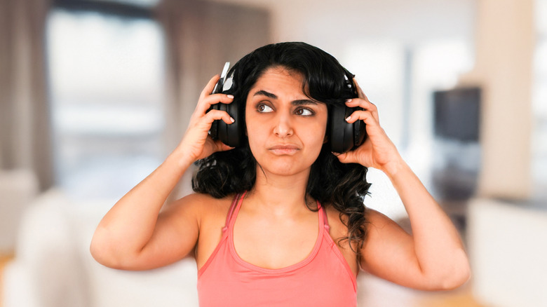 Person looking annoyed while wearing headphones
