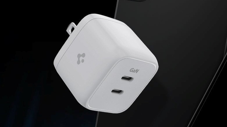 A Spigen dual-port charger against a dark background