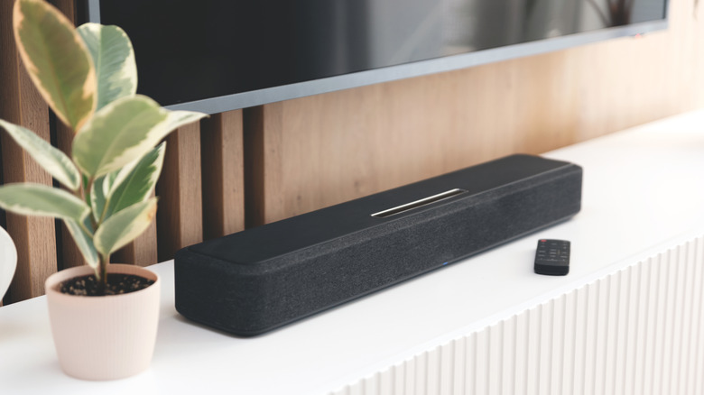 A soundbar and remote beneath a smart TV