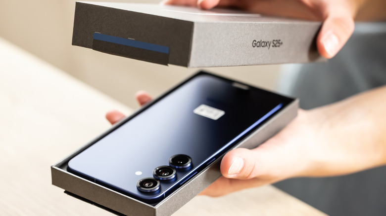 Someone opening the box of a new Samsung Galaxy S25 Plus smartphone.
