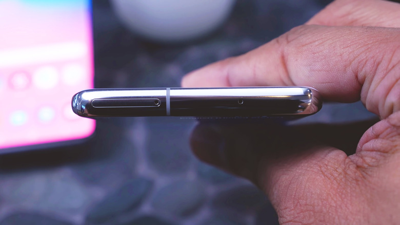 a person holding a phone that shows a side-view for the micro SD slot