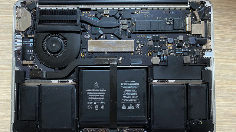 A MacBook sitting on a table, open to show its internal components