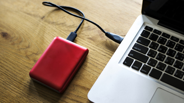 A laptop with an external drive attached to it