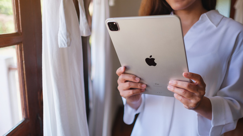 A woman holding an Apple iPad.