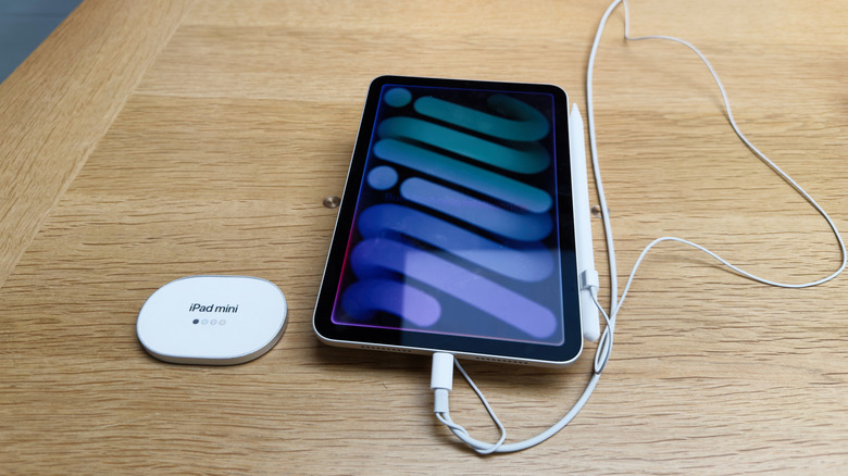 An iPad Mini charging on a desk in store.