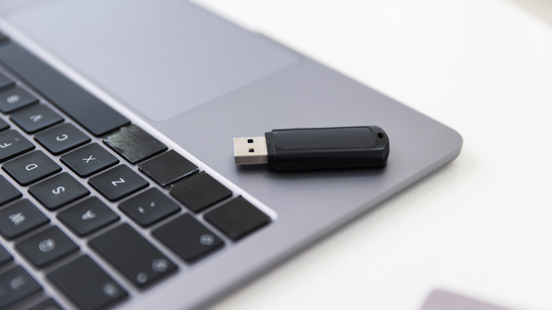 a usb drive sitting at the edge of the laptop