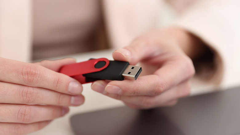 a person holding a usb drive in their hands