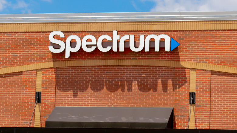 The Spectrum logo mounted on the exterior of a brick building.