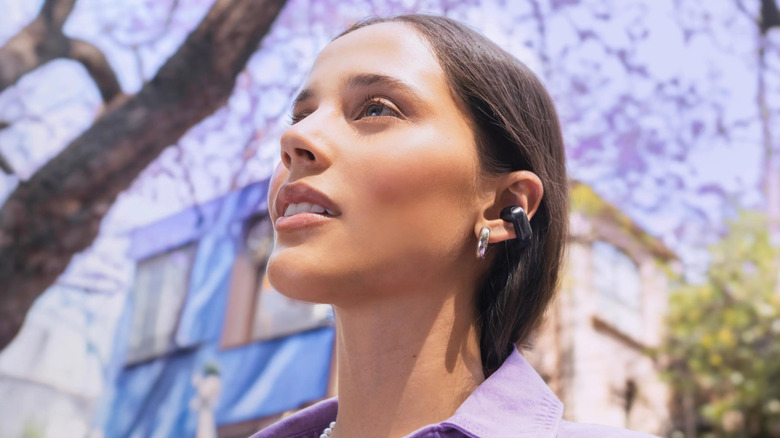 A person wearing the Bose Ultra Open-Ear earbuds