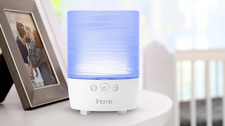 iHome Portable Bluetooth Candle Speaker placed next to phot frame on a white table
