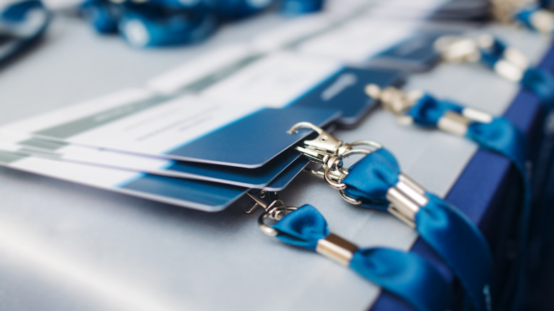 Lanyards with ID badges and metal clips arranged on a table.