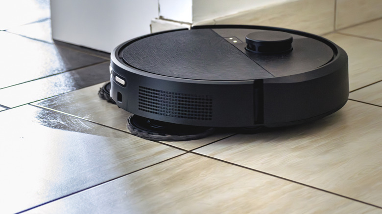 Smart robot vacuum and mop cleaning a tile floor