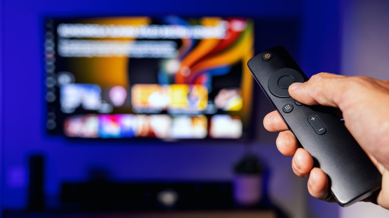 Person holding remote with a smart TV in background