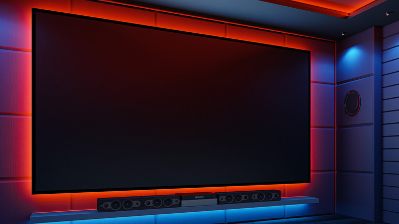 A wall-mounted TV and soundbar in a theater room.