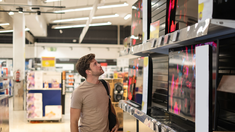 A customer looking at TVs in a store