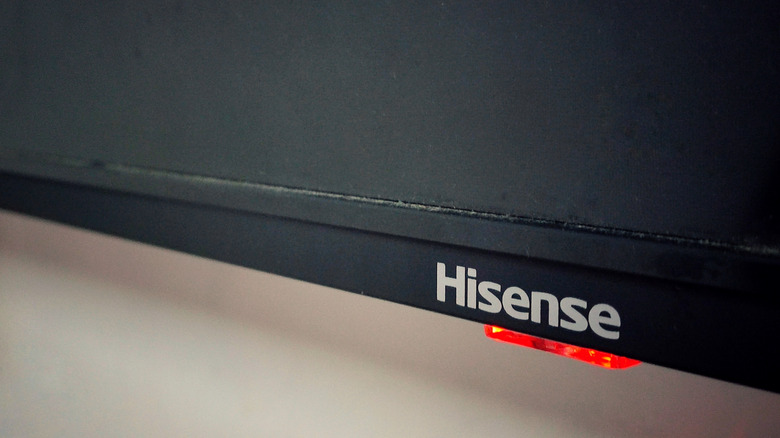 Close-up of a Hisense TV logo with a red indicator light underneath.