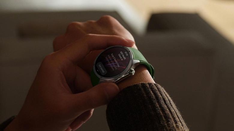 A person pressing a button on the OnePlus Watch 3