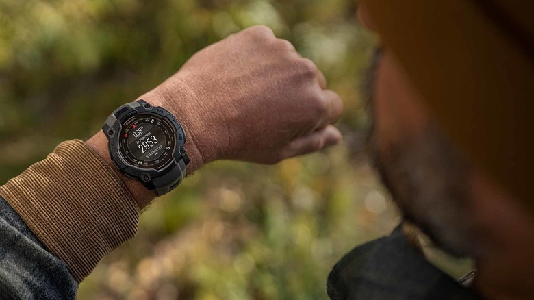 Close up of a man checking a rugged looking smartwatch on his wrist