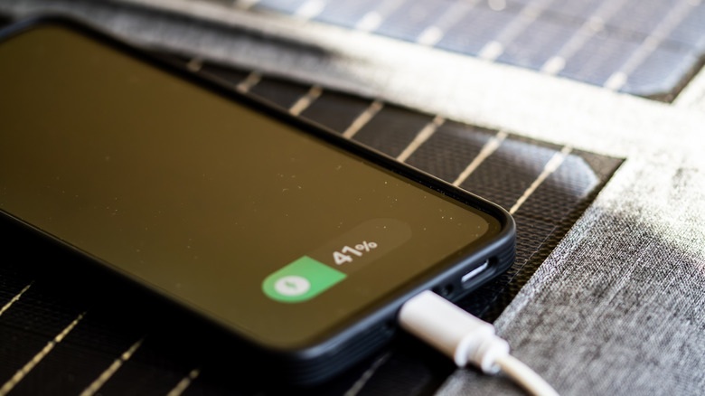 Close up of a smartphone charging while lying on solar panels