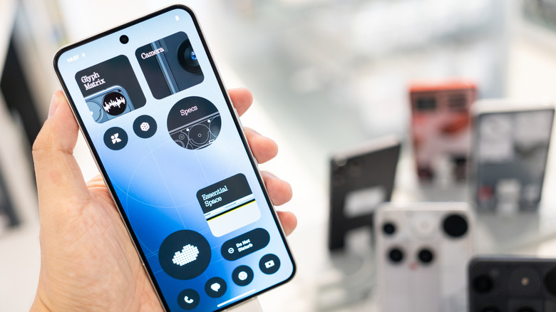 A Nothing Phone with its bright display being held in hand.